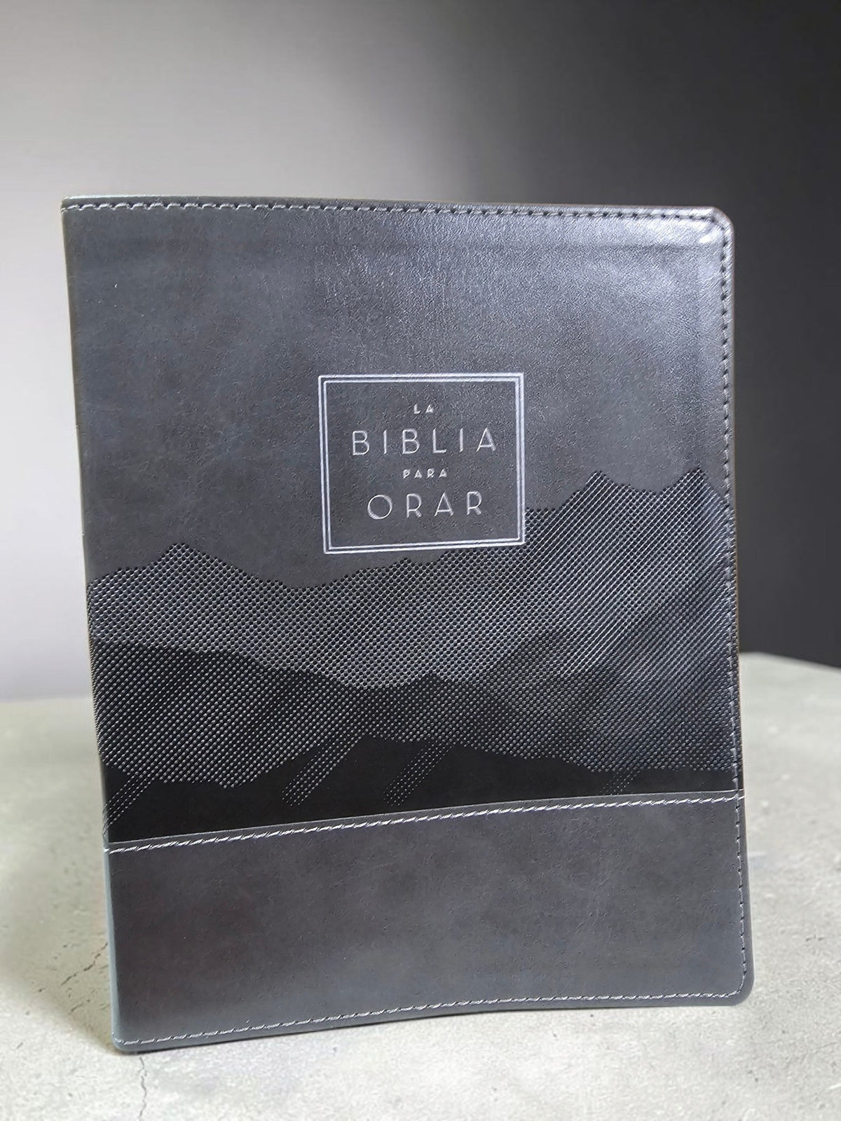 Biblia para Orar Libreria Wow edición Reina Valera con cubierta de cuero sintético gris oscuro y diseño texturizado.