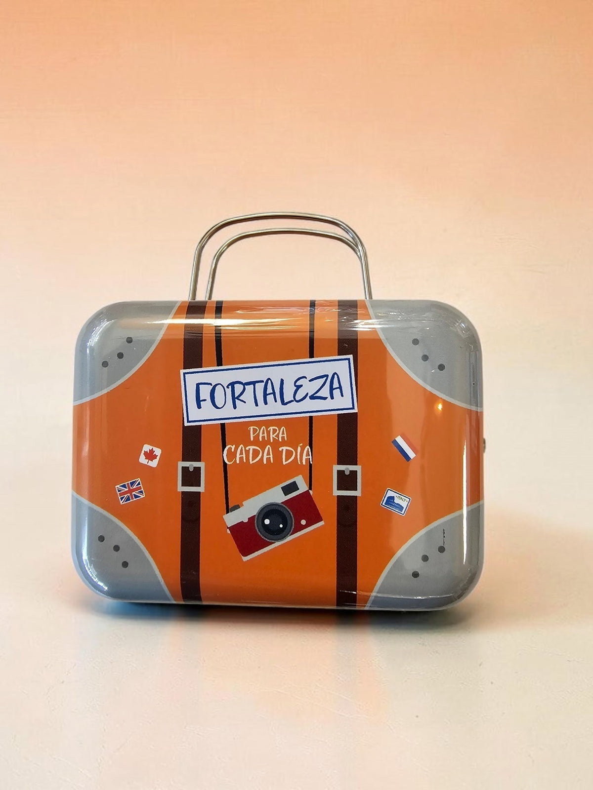 Caja metálica decorativa Libreria Wow con diseño de maleta vintage, color naranja y gris, ideal para organizar.