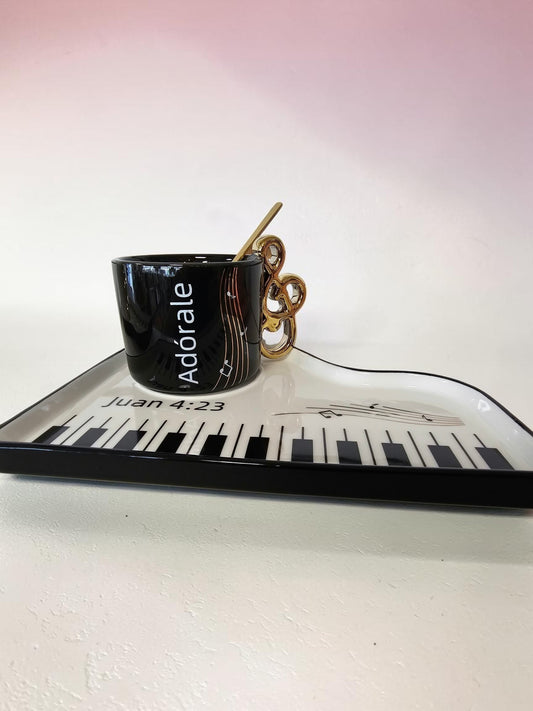 Set de taza negra Libreria Wow con asa de clave de sol dorada y bandeja en forma de piano con teclas y pentagrama.