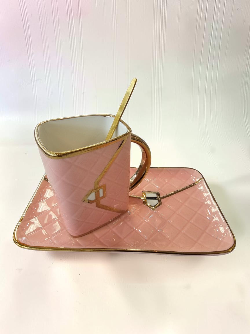 Set de taza y plato Libreria Wow rosa pastel con textura acolchada, detalles dorados y cuchara a juego.
